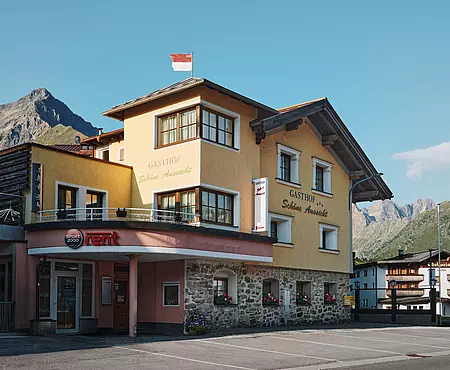 Außenansicht vom Gasthof "Schöne Aussicht" mit gelber Fassade und rotem Eingangsbereich