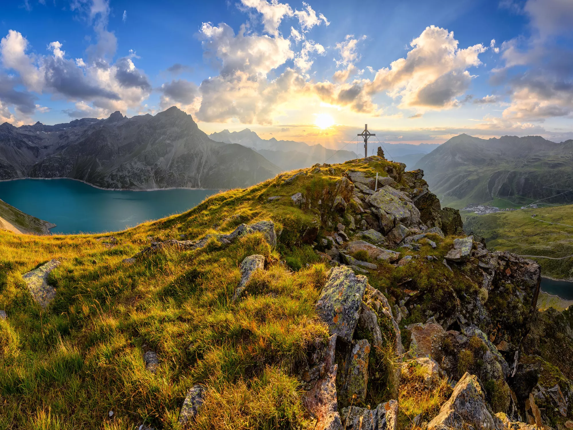Panorama Aussicht bei Sonnenuntergang mit Gipfelkreuz und Speichersee