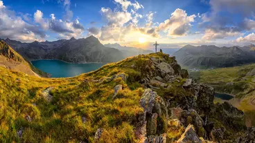 Panorama Aussicht bei Sonnenuntergang mit Gipfelkreuz und Speichersee