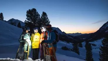 Rodeln bei Sonnenuntergang in einer Schneelandschaft