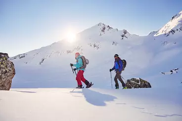 Zwei Skitourengeher im Gelände bei Sonnenschein
