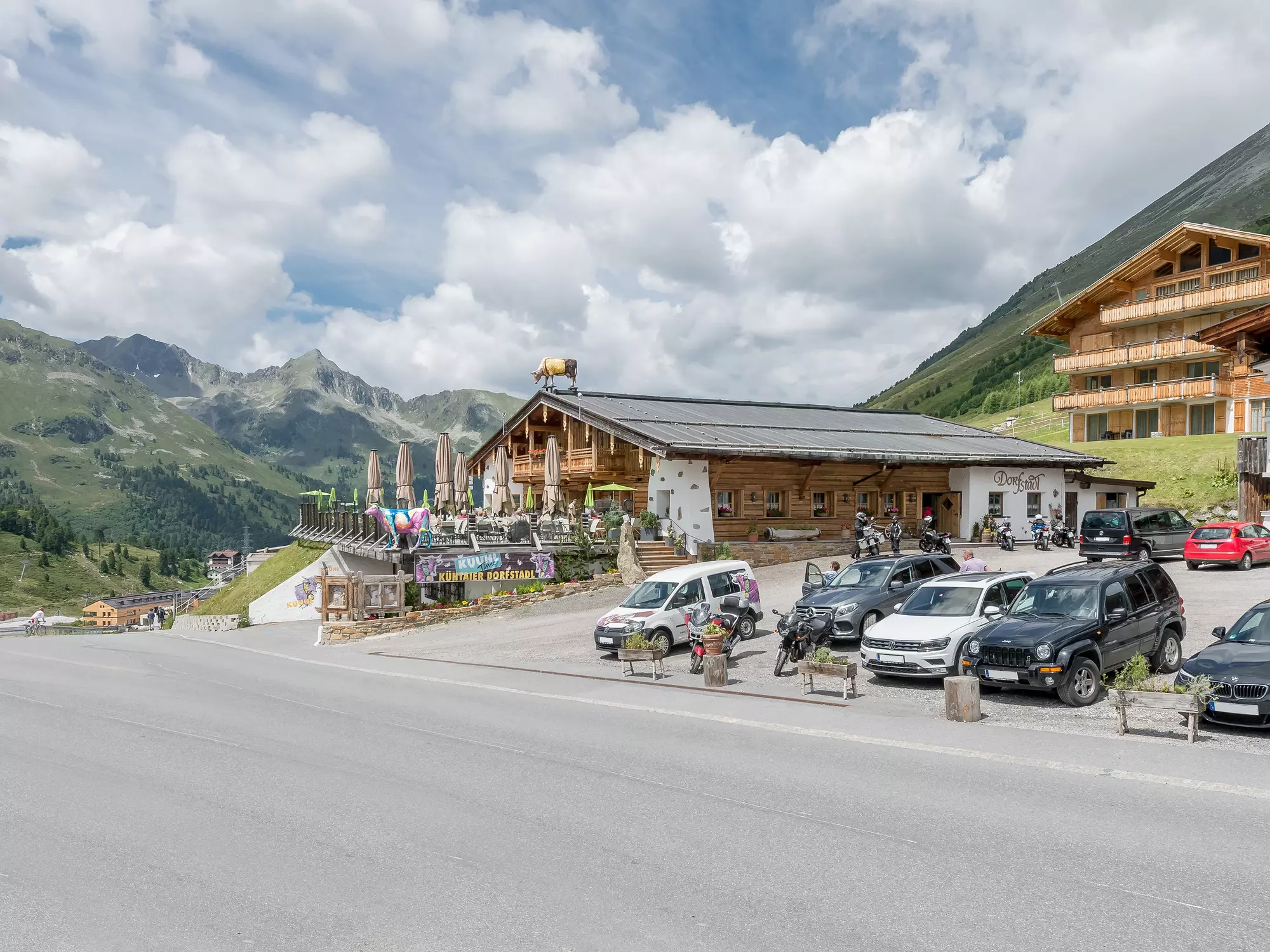 Außenansicht Dorfstadl mit großem Parkplatz und Bergpanorama